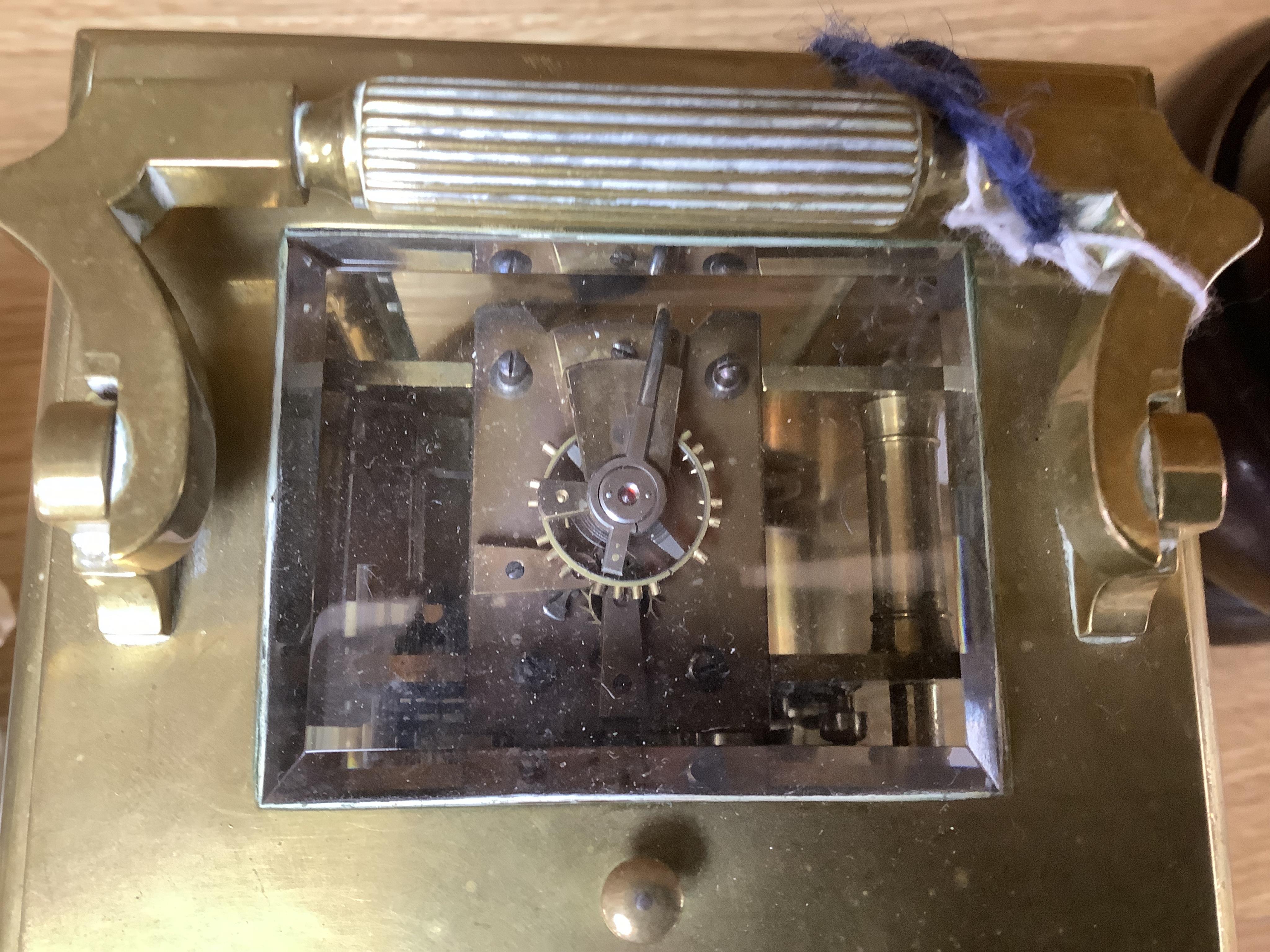 A large brass repeating carriage clock with key and ornate filigree dial, 17cm high (including handle). Condition - good, unchecked if working